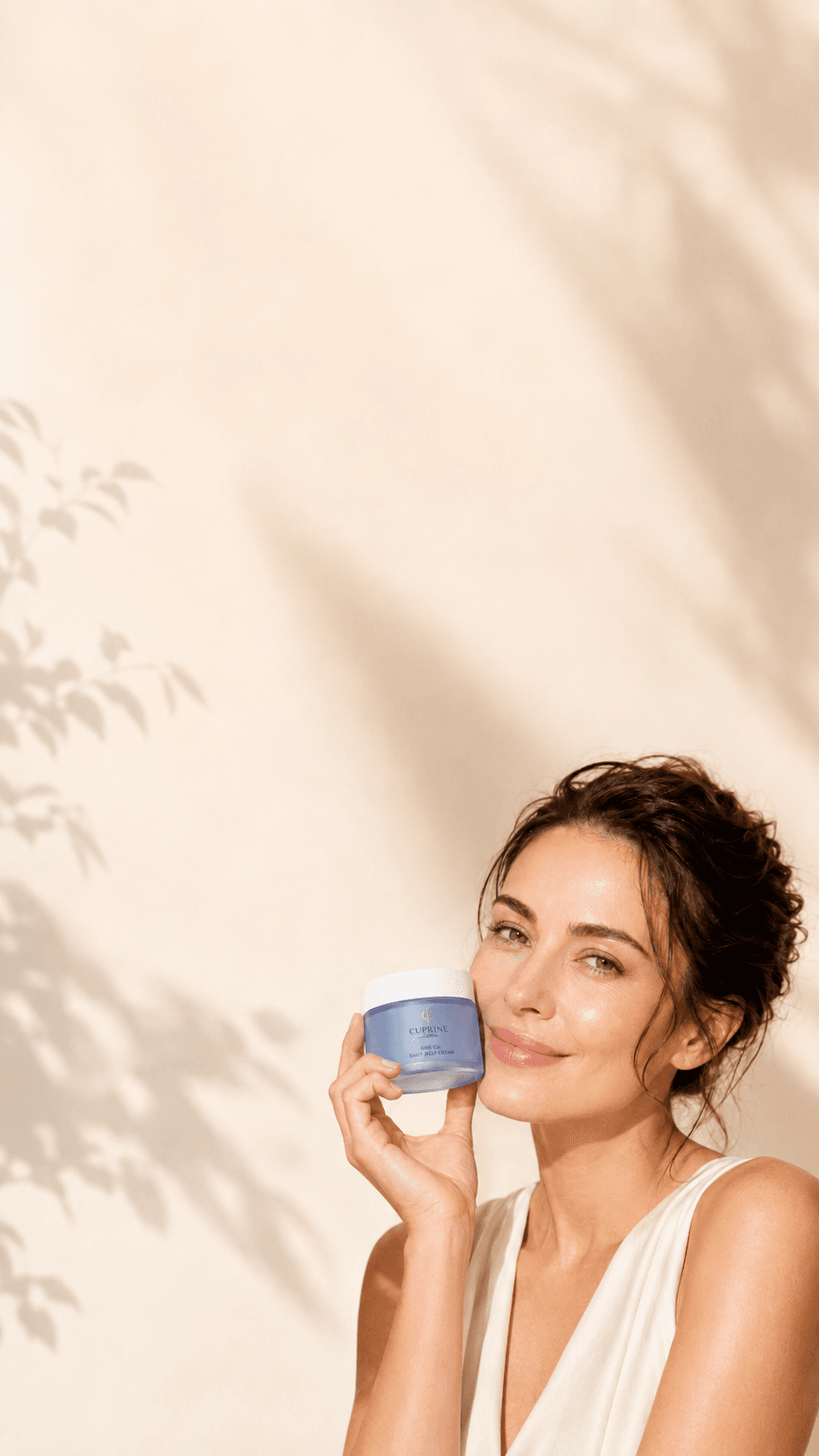 A woman with glowing skin holding a jar of Cuprine GHK-Cu Daily Jelly Cream